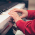 Детские руки на клавишах фортепиано.